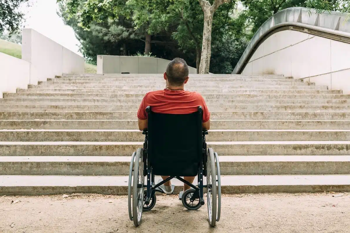Représentation d'une personne en fauteuil roulant, symbolisant la vie avec un handicap.