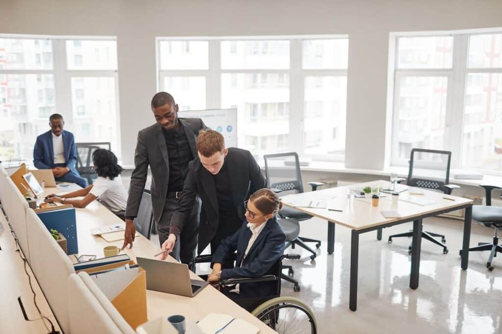 Une personne handicapée avec des collègues ou des responsables, mettant en évidence l'inclusion au travail.