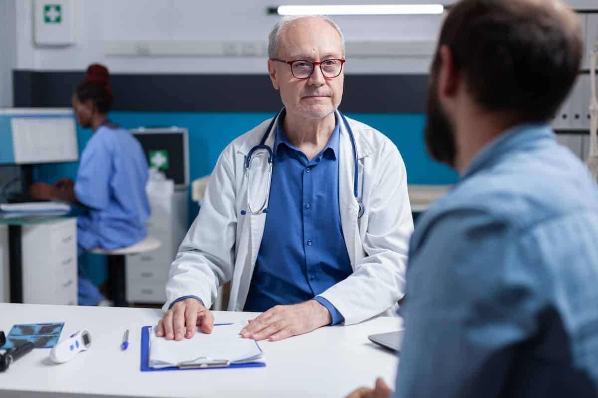 Illustration d'une consultation médicale montrant les zones de douleur de la névralgie d'Arnold avec un médecin et un patient.