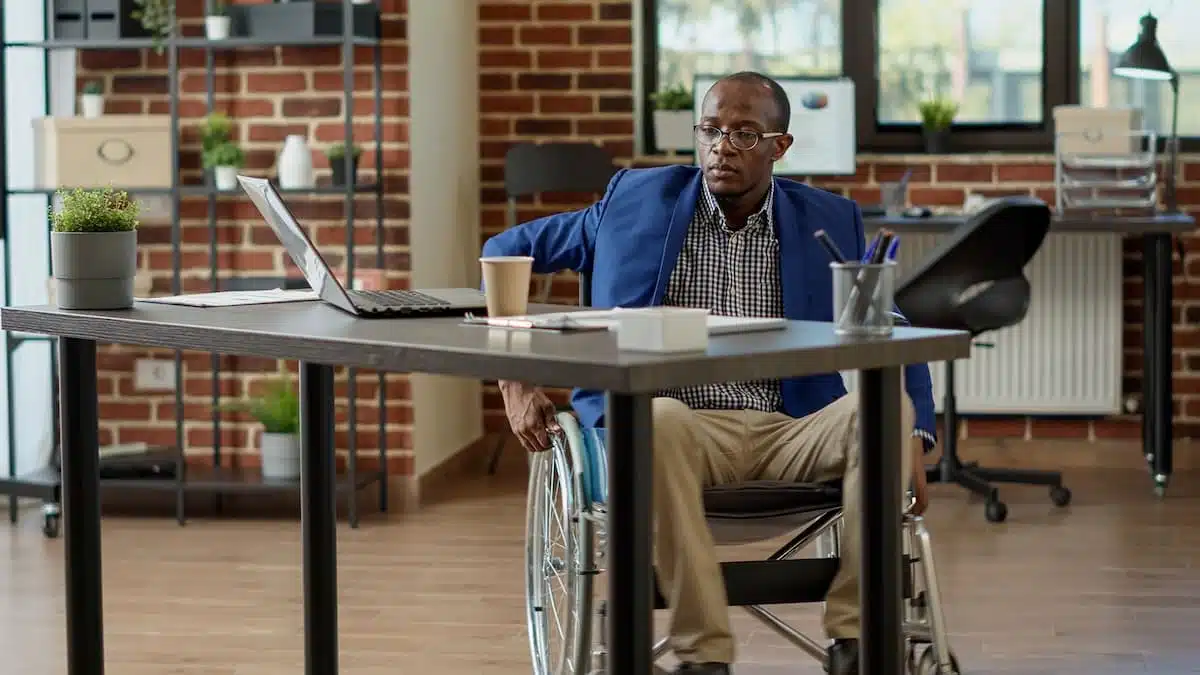 Illustration d'un employeur et d'un travailleur handicapé discutant au bureau.