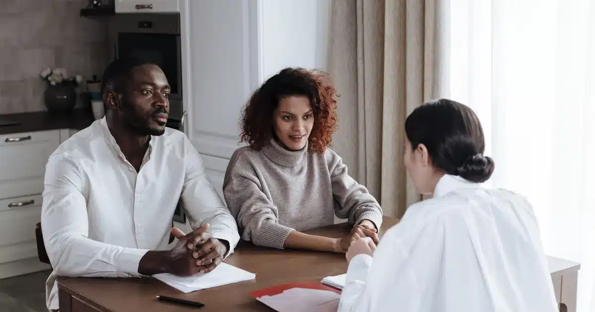 Droit du surendettement 10 Parent et conseiller social examinant ensemble des documents administratifs lors d'une réunion de suivi.