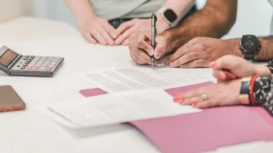 Personne guérie d'un cancer signant un contrat de prêt immobilier dans une banque
